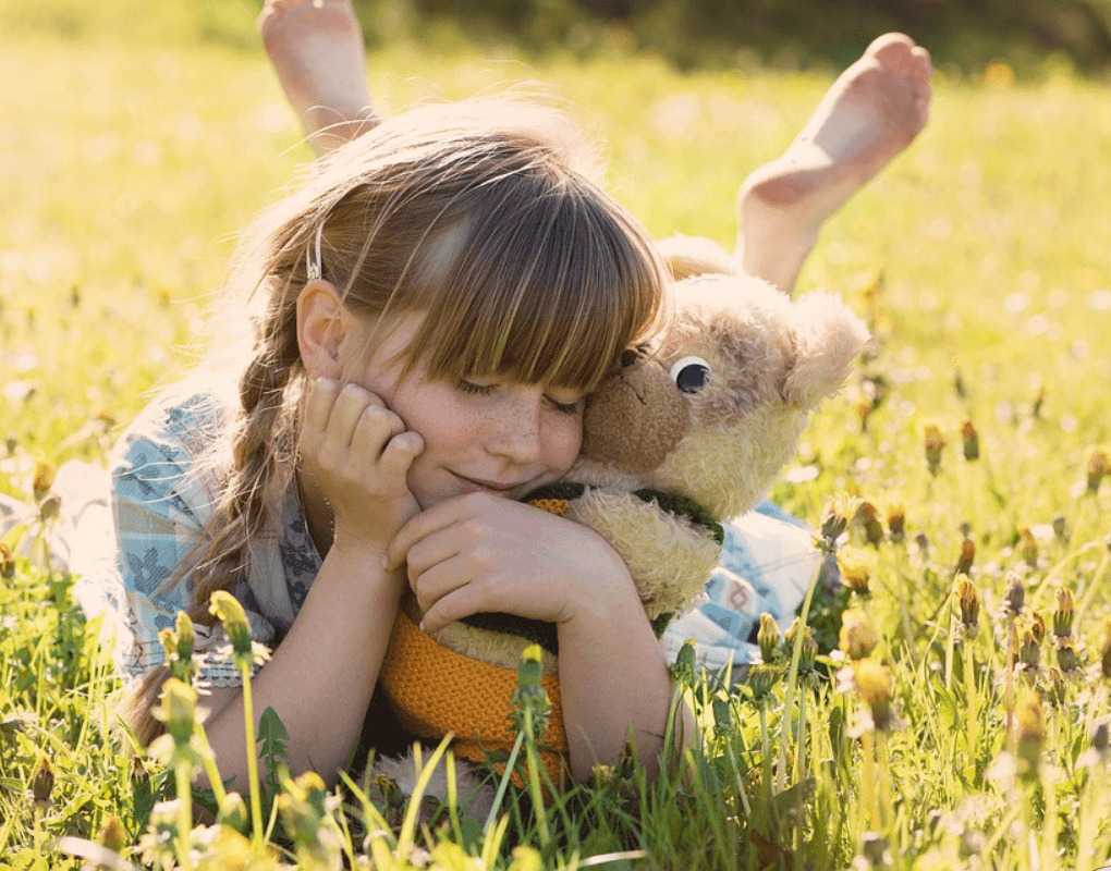 Criança brincando com bichos de pelúcia 