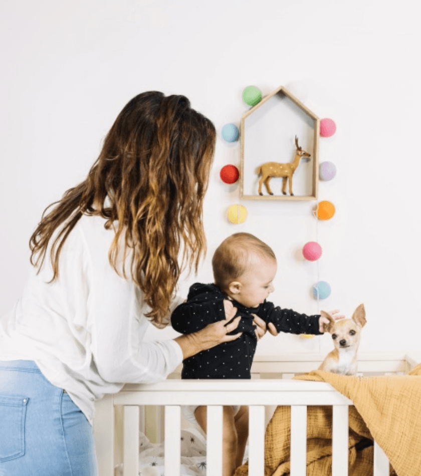 mamãe colocando o bebê para dormir no berço